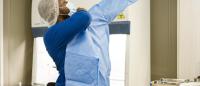a young man puts on ppe as he prepares to manage infectious disease