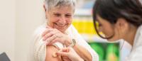A healthcare provider administers a vaccine to an older adult.